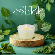 SerrBeauty Pfefferminz Bienenwachs Duftkerze 125 g auf einem Holzpodest, umgeben von frischen Minzblättern. Handgefertigte, biologische Kerze für entspannende Aromatherapie.